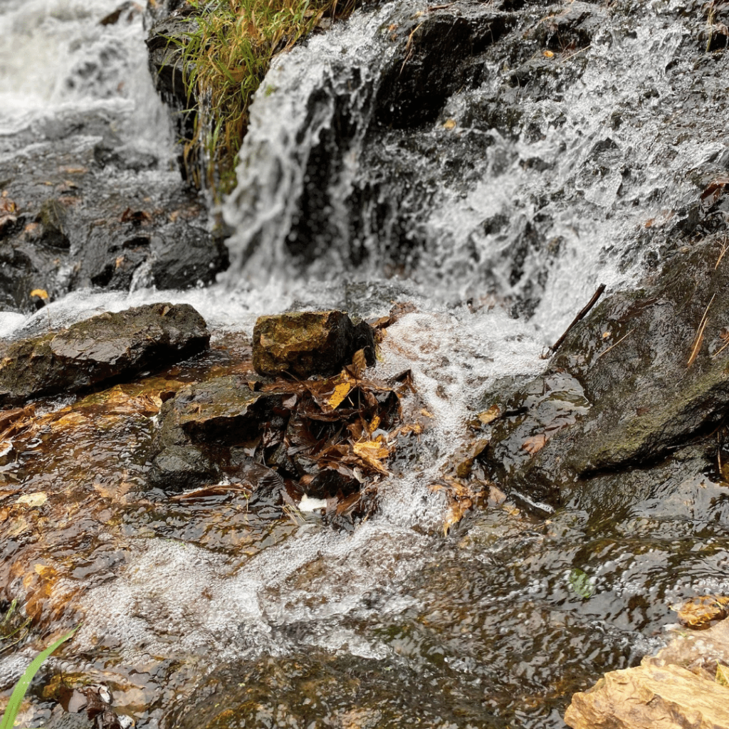 Water rushing down rocks in a mini water fall